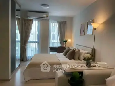 Modern bedroom with cozy decor and natural light in a stylish apartment.
