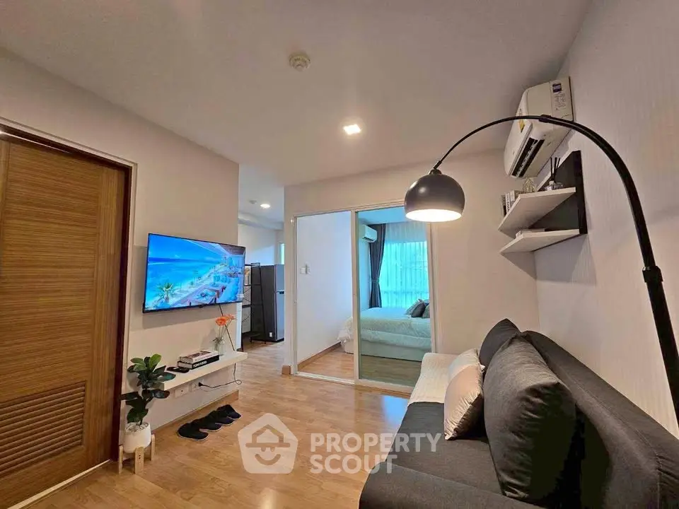 Modern living room with sleek design and cozy ambiance, featuring a wall-mounted TV and stylish decor.