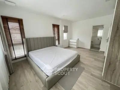 Spacious modern bedroom with ensuite bathroom and stylish wooden flooring