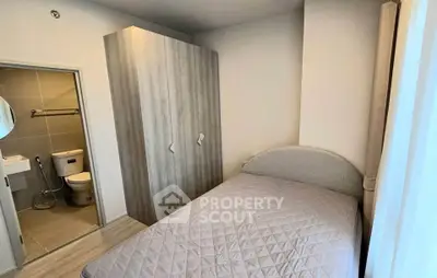 Cozy bedroom with ensuite bathroom and modern wardrobe in a stylish apartment.