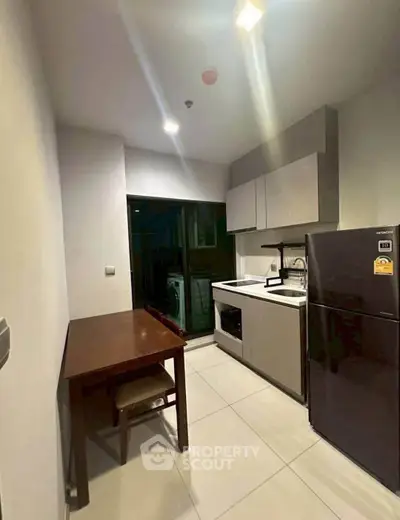 Modern kitchen with sleek cabinetry and stainless steel appliances in compact layout.