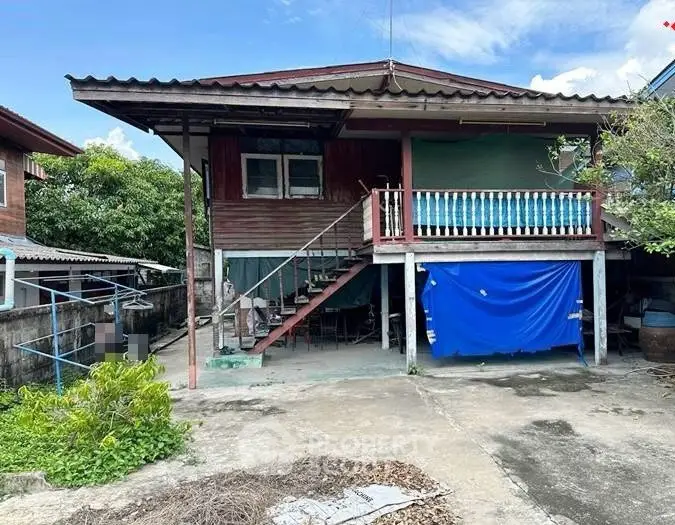 Charming rustic wooden house with elevated porch and spacious outdoor area, perfect for renovation enthusiasts.