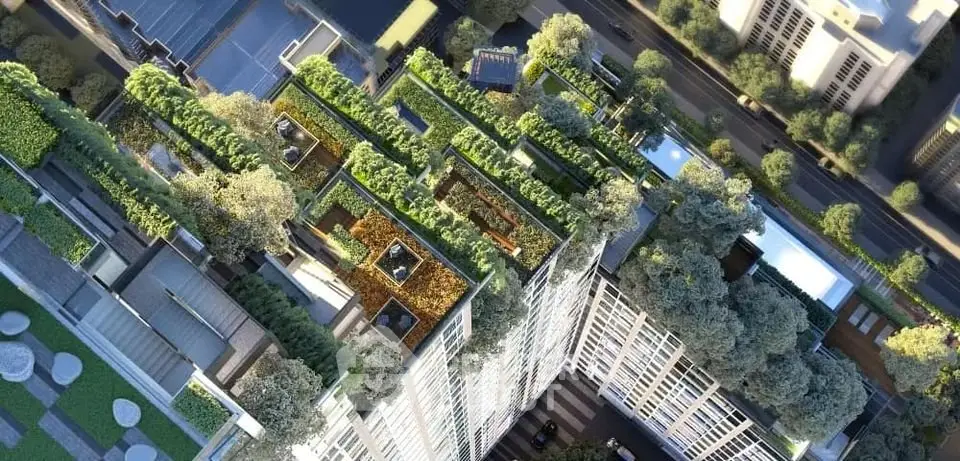 Stunning aerial view of a modern building with lush green rooftop gardens in an urban setting.