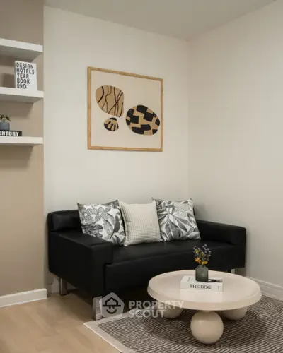 Modern living room with stylish black sofa and abstract art on the wall.