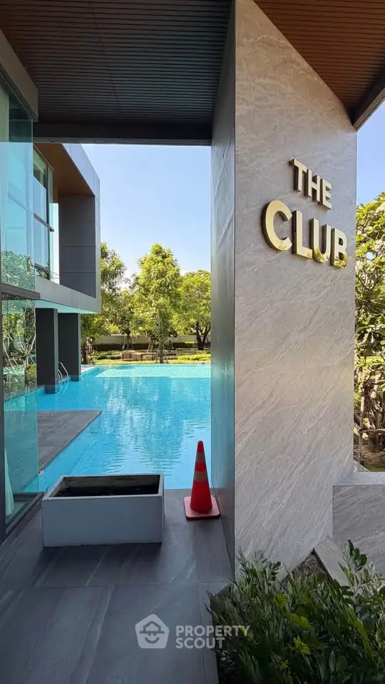Luxurious poolside view at modern residential club with lush greenery