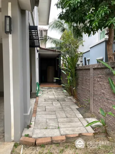 Charming side pathway with lush greenery in a modern residential property