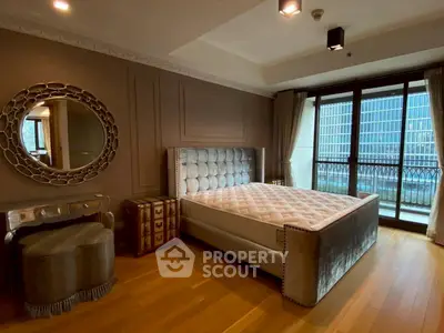 Luxurious bedroom with elegant decor and city view balcony.