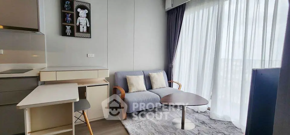 Modern living room with cozy sofa, stylish decor, and natural light from large windows.