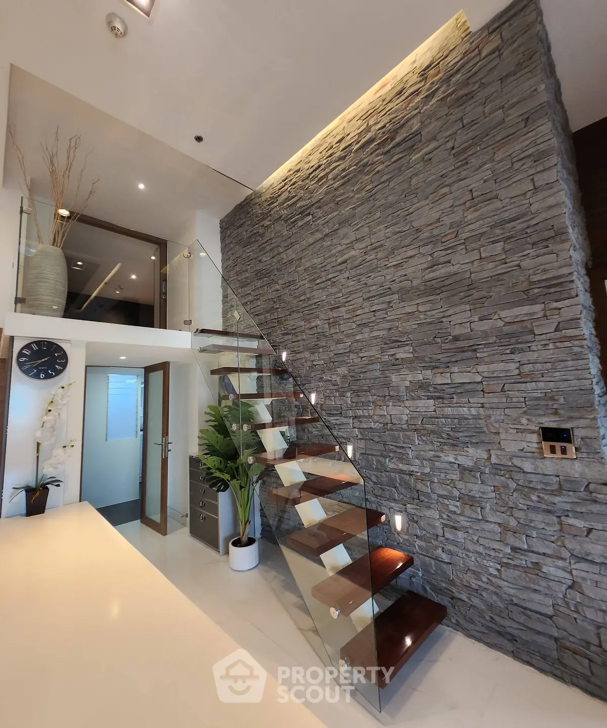 Modern interior with stylish staircase and stone accent wall