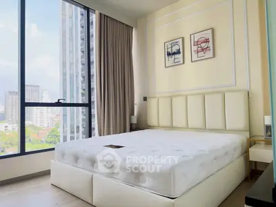 Modern bedroom with large window and city view, featuring stylish decor and comfortable bed.