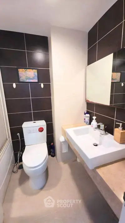 Modern bathroom with sleek fixtures and dark tile accents