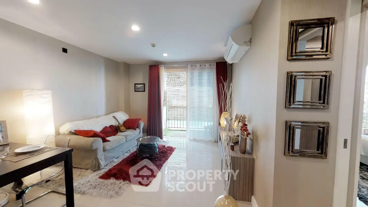 Stylish living room with modern decor and large windows opening to a balcony.