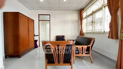 Spacious living room with classic wooden furniture and large window.
