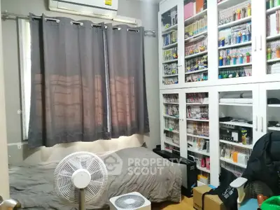 Cozy bedroom with built-in bookshelves and air conditioning, perfect for book lovers.