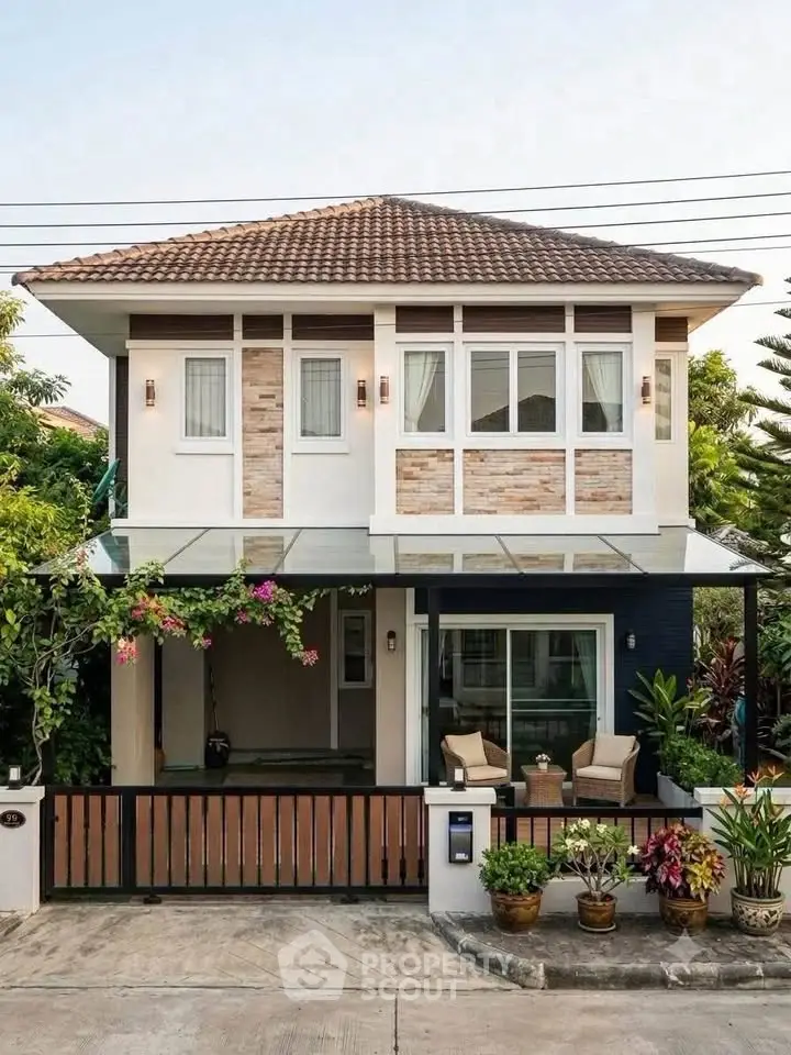 Charming two-story house with modern facade and lush garden, perfect for family living.