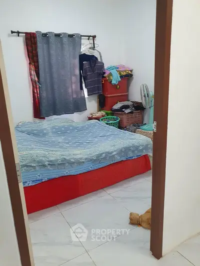 Cozy bedroom with simple decor and tiled flooring, ideal for compact living.