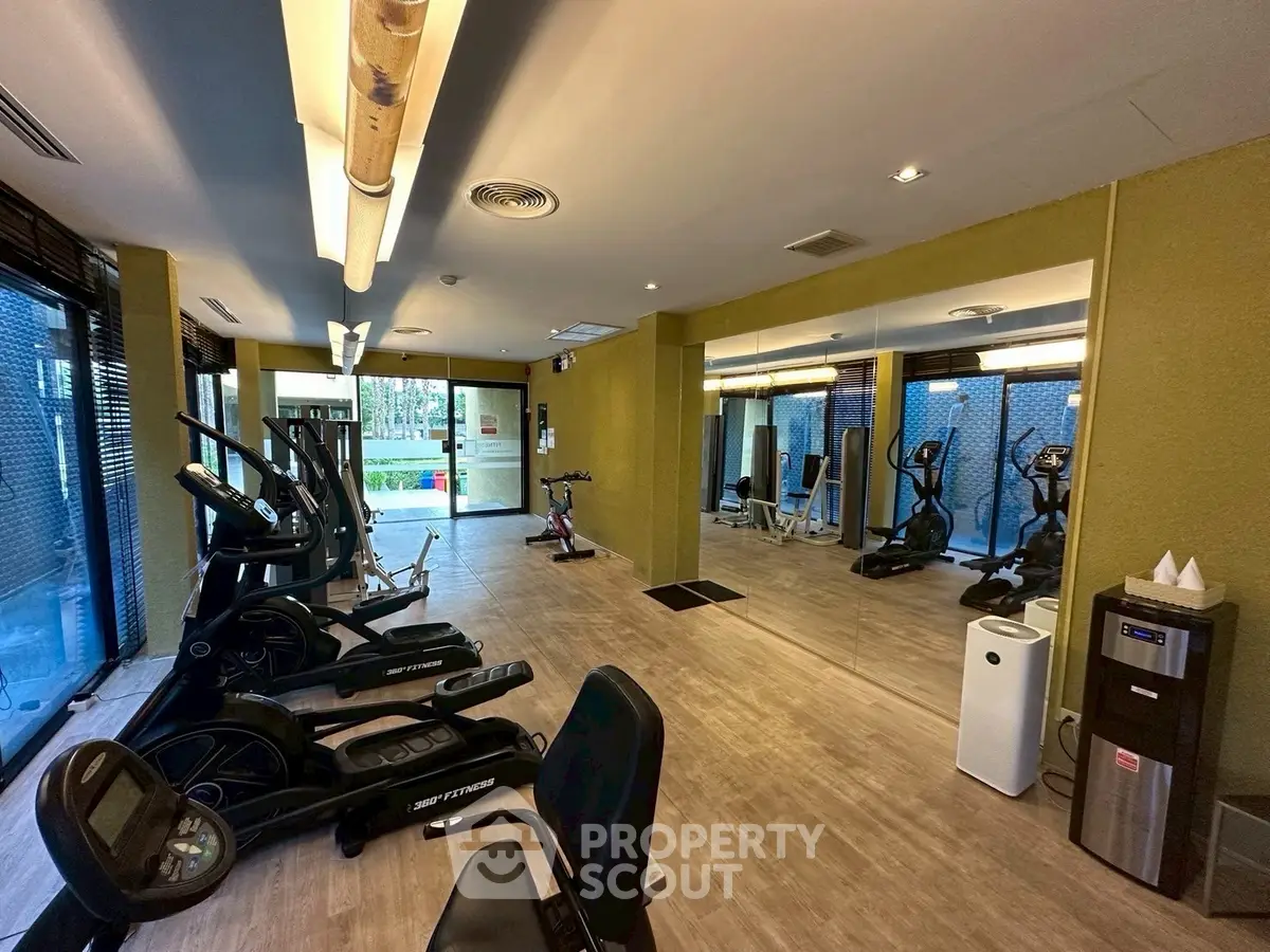 Modern gym with state-of-the-art equipment and mirrored walls in a residential building.