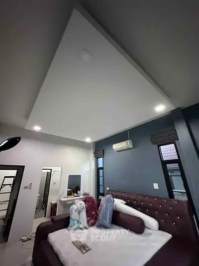 Spacious bedroom with modern ceiling design and plush furnishings