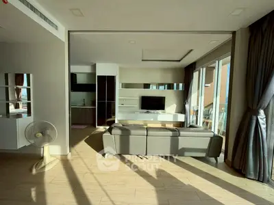 Spacious modern living room with natural light and stylish decor in a luxury apartment.