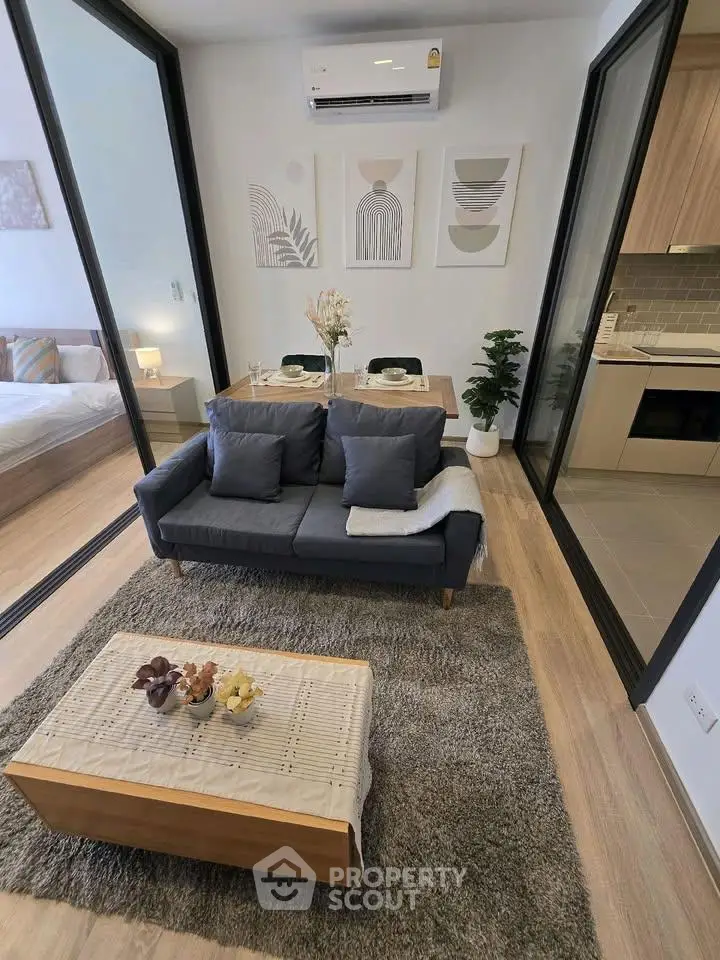 Modern living room with stylish decor, open layout, and adjacent kitchen in a contemporary apartment.