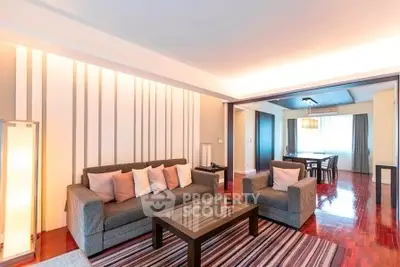 Spacious modern living room with stylish decor and open dining area, featuring hardwood floors and elegant lighting.