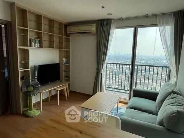 Modern living room with city view, featuring cozy sofa, TV, and large window balcony access.