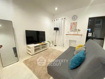 Modern living room with sleek decor and large TV, perfect for relaxation.
