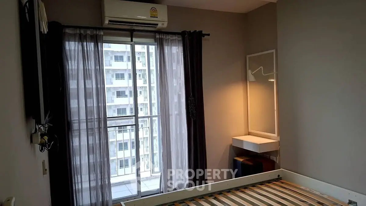 Modern bedroom with large window and city view, featuring sleek furniture and air conditioning.