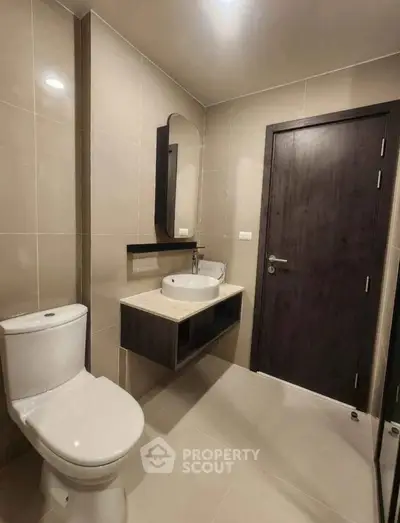 Modern bathroom with sleek fixtures and neutral tones, featuring a stylish vanity and contemporary design.