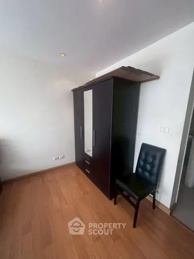 Spacious bedroom with wooden flooring and modern wardrobe