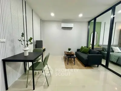 Modern living room with sleek furniture and glass partition leading to bedroom
