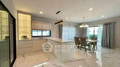 Luxurious open-plan kitchen and dining area with marble flooring and elegant lighting.
