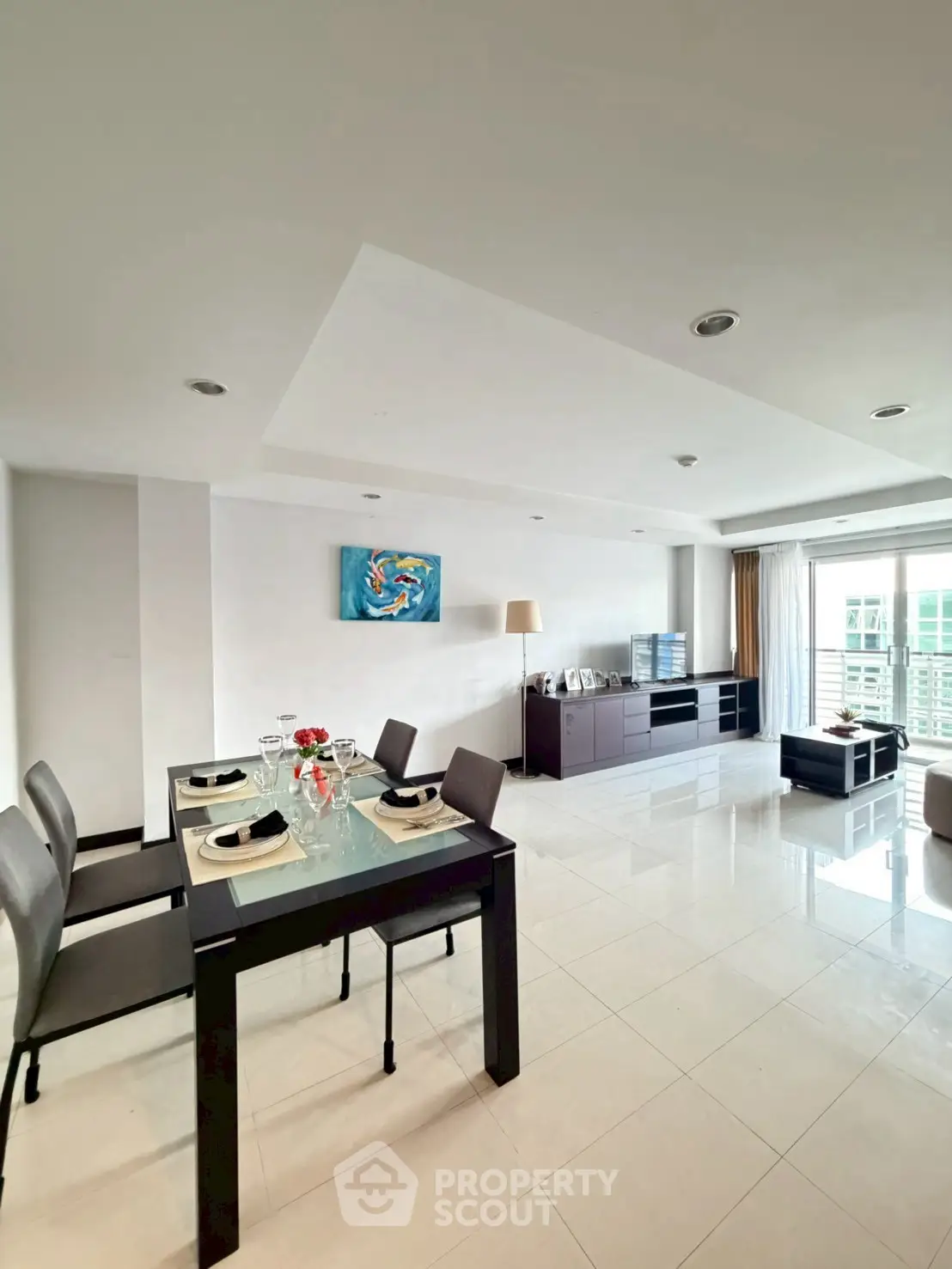 Spacious modern living room with dining area and large windows offering natural light.