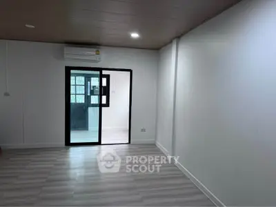 Spacious modern living room with sleek flooring and large windows for natural light.