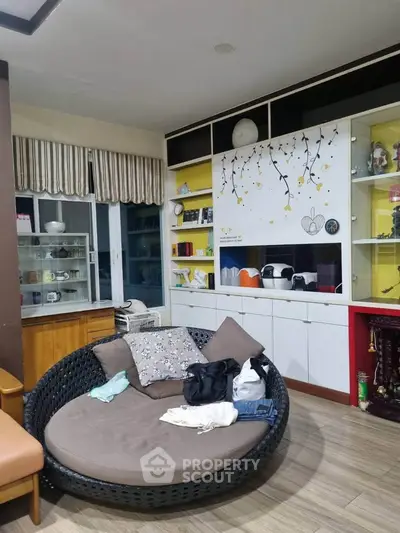 Cozy living room with stylish round sofa and decorative shelving