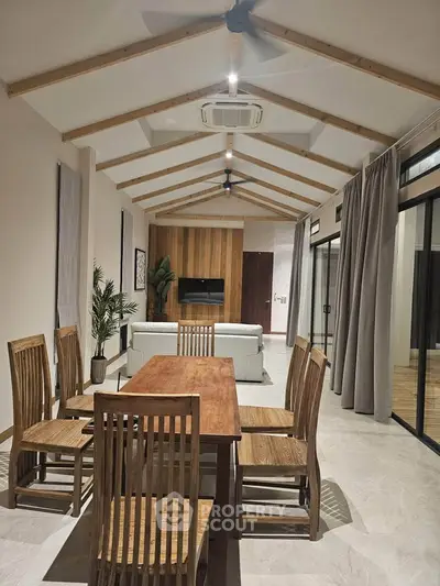 Spacious modern living room with high ceilings and elegant wooden dining set