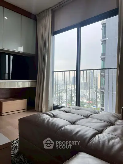 Modern living room with city view from large window, featuring sleek furniture and elegant decor.