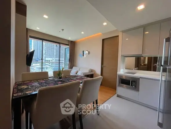 Modern open-layout living and dining area with city view, sleek kitchen appliances, and elegant decor.