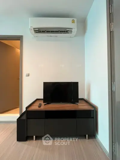 Modern living room with sleek TV stand and air conditioning unit, perfect for cozy relaxation.