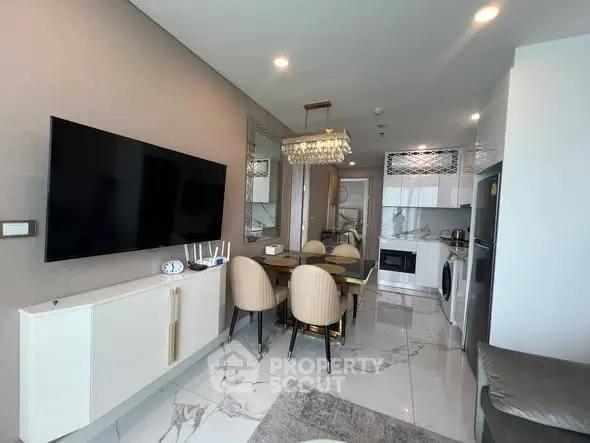 Modern open-layout living room with sleek kitchen and dining area, featuring marble flooring and elegant decor.
