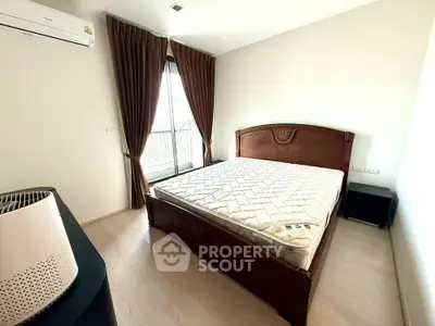 Spacious bedroom with elegant wooden bed and large window for natural light.