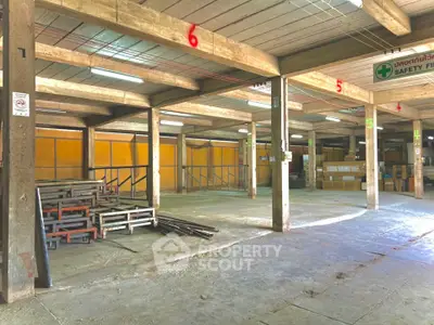 Spacious industrial warehouse interior with concrete floors and ample storage space.