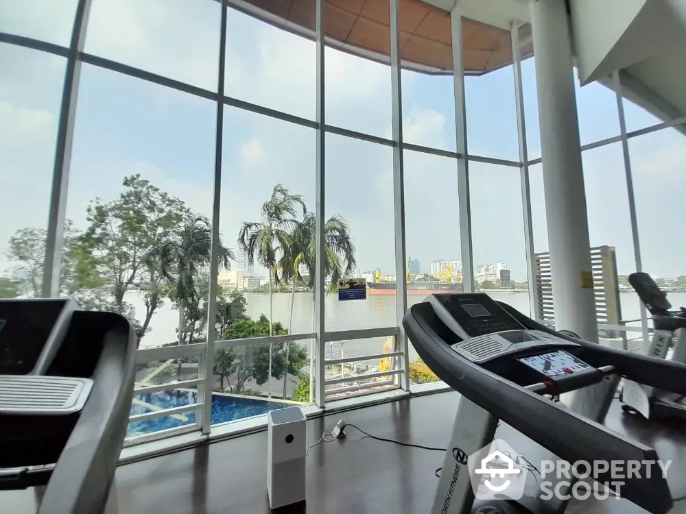 Spacious gym with panoramic river view and modern equipment