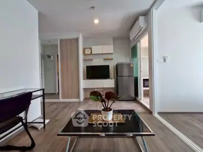Modern living room with sleek furniture and open layout, featuring a stylish TV unit and air conditioning.