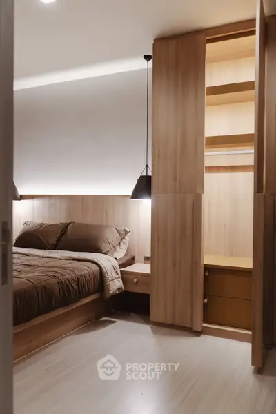 Modern bedroom with wooden accents and built-in storage, featuring cozy lighting and elegant design.
