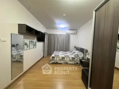 Spacious modern bedroom with wooden flooring and stylish decor