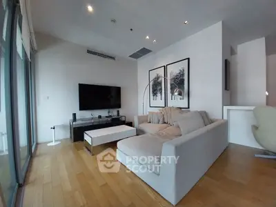 Modern living room with sleek design, featuring a cozy gray sofa, large TV, and stylish decor in a bright, airy space.