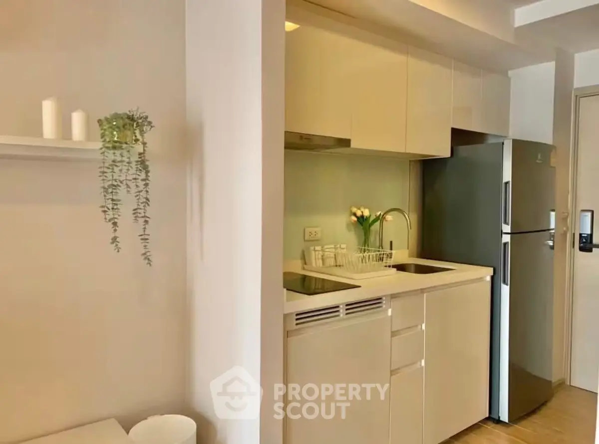 Modern compact kitchen with sleek cabinets and stainless steel fridge