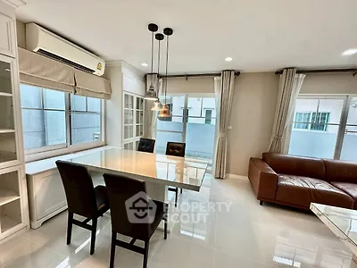 Modern living room with sleek dining area and large windows for natural light