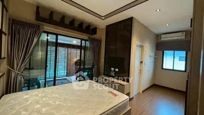 Spacious bedroom with modern decor and large windows for natural light